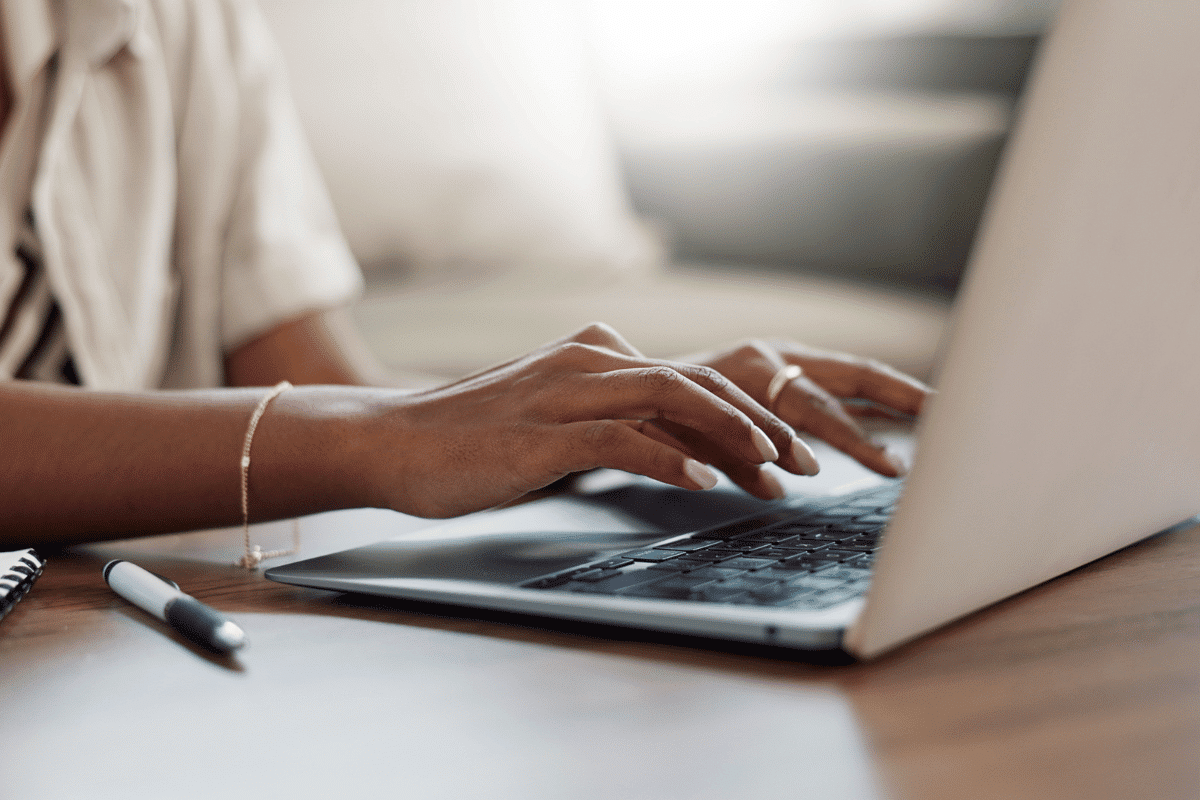 Woman typing on a laptop while writing a blog post