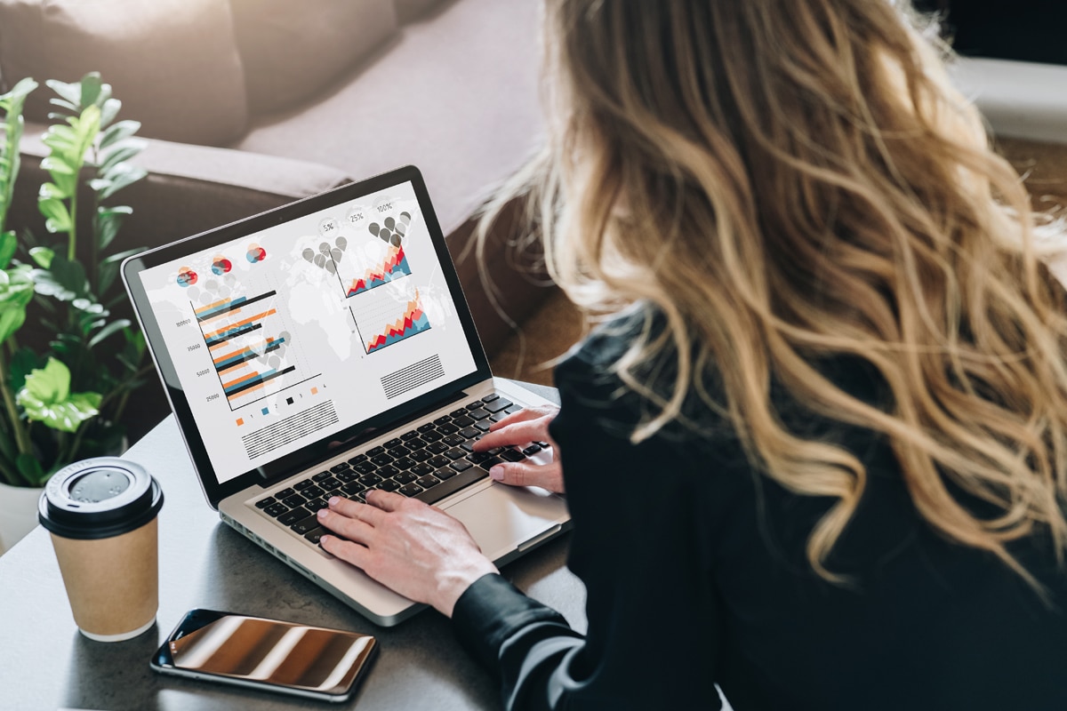 Woman working on a laptop while planning website service pages.