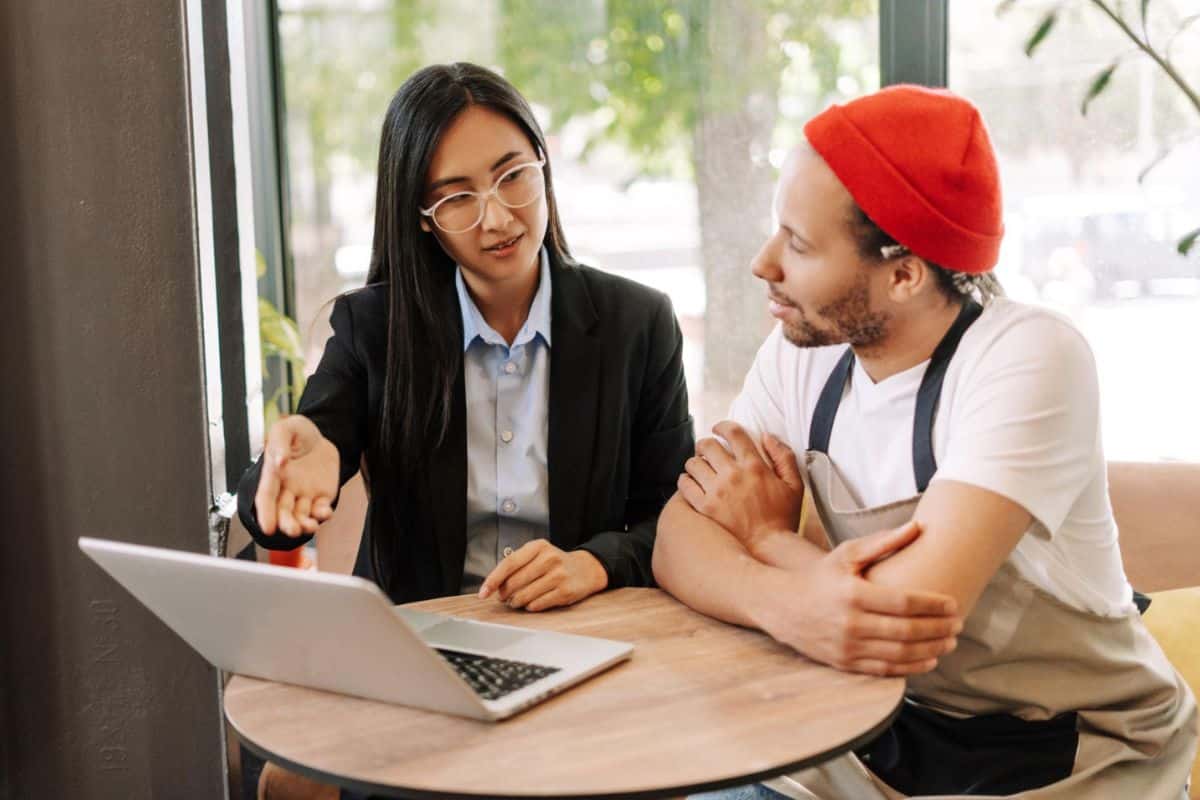 Business consultant helping a small business owner plan practical workflow automation using existing software
